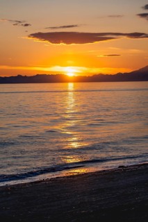 View of Cook Inlet at sunset, picturesque golden light of the midnight sun, mountains of the