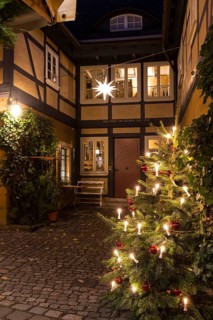 Decorated Christmas tree and Herrnhut star on a half-timbered house in the historic village center