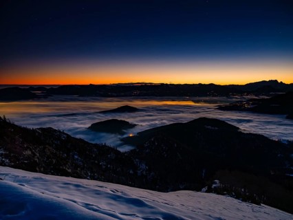 Alpine panorama at dawn in winter, fog in the valley, partly illuminated from below, Untersberg,