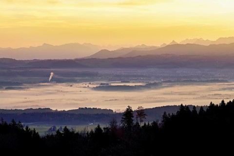 View from Horben of the Reuss Valley covered in fog, behind it the Glarus Alps in the light of the