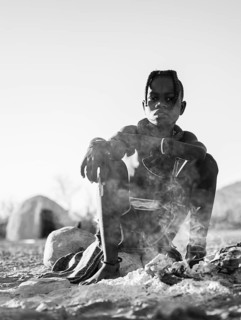 Black and white, Himba child at the fire early in the morning, traditional Himba village,