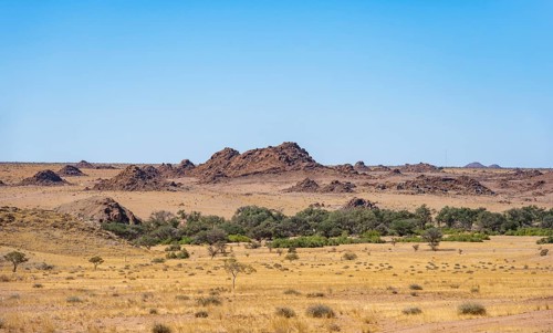 Desert landscape, barren landscape with hills of stacked rocks, Ugab River riverbed, Brandberg,