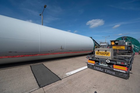 Overlong heavy-duty transporter with a part of a wind turbine, at a motorway rest area of the A9,
