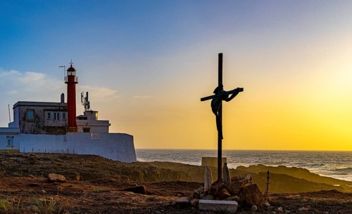 Religious scene, temporary Christian cross on the coast, Farol de Cabo Raso lighthouse, Sao Bras de