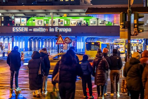 The main train station in Essen, blue illuminated underpass, bus station, am Europaplatz, train on