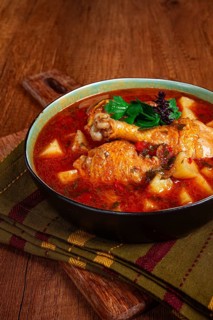 Souzi soup. Georgian dish, meat with oats, tomato sauce and herbs, on a wooden table