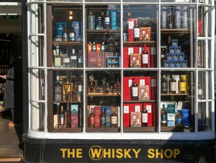 Shopfront window display The Whisky Shop store, Cathedral Close, Exeter city centre, Devon,