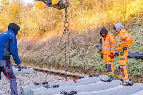 Workers lay concrete ties with an excavator under sunny autumn skies, Hermann Hesse Railway track
