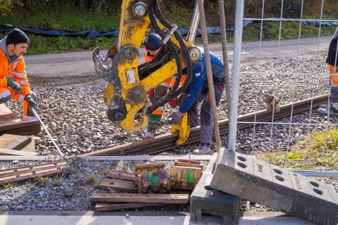 Construction workers install rails on a construction site with heavy equipment, Hermann Hesse