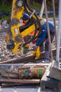 Construction workers work together on rails with heavy equipment, track construction of the Hermann