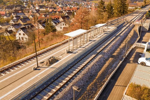 Aerial view of a rural train station with platform roof and tracks in the village, new Hermann