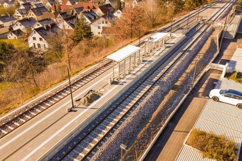 Station environment with platforms and apartments, autumnal atmosphere, drone image with parked