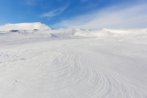 Desolate windswept snow covered Arctic landscape at Mohnbukta, bay at the western shore of