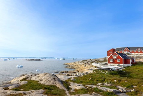 Typical architecture of Greenland Ilulissat with colored houses located near fjords and icebergs
