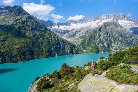 Female mountaineer in front of picturesque mountain landscape, turquoise-blue mountain lake