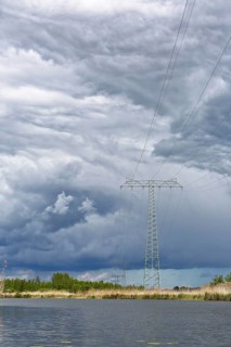 A large power pole in a vast landscape under dramatic clouds, Peenetal nature park Park,