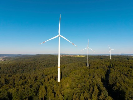 Wind turbines over dense forest stretch into the vastness of the sky, near Schorndorf, Remstal,