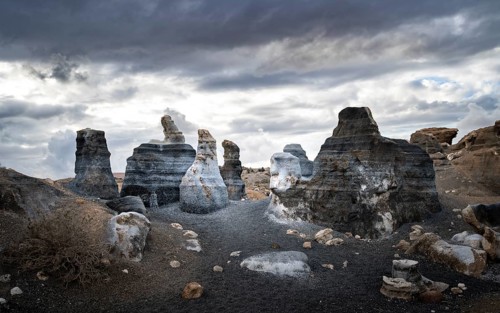 Eroded rock formations, volcanic landscape with dramatic cloudy skies, Ciudad Estratificada or Los