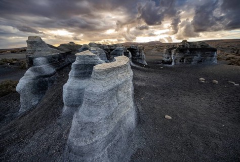 Eroded rock formations, volcanic landscape with dramatic cloudy sky at sunset, Ciudad Estratificada