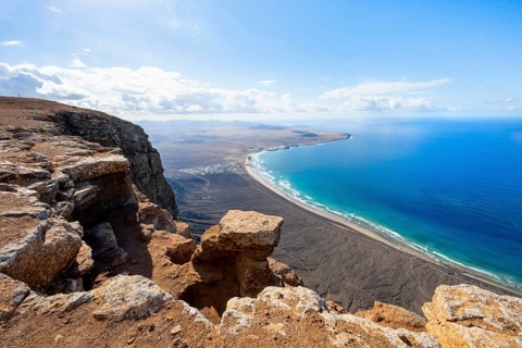 View from the Risco de Famara Cliff to Famara Beach, Playa de Famara with La Calaeta, Lanzarote,