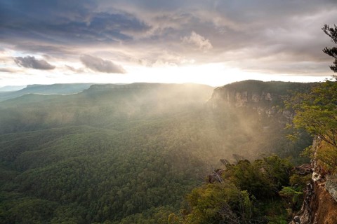 Evening sky with clouds of fog and setting sun at the Three Sisters at Echo Point in Katoomba, Blue