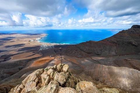 View from the Risco de Famara cliffs to the coast and the sea with the Famara beach, Playa de