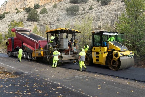 Asphalt road construction team of workers resurfacing tarmac in rural area, near Albarracin, Teruel