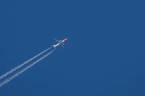 Boeing 737 jet passenger aircraft of Norwegian Air airlines flying in a blue sky with contrails or