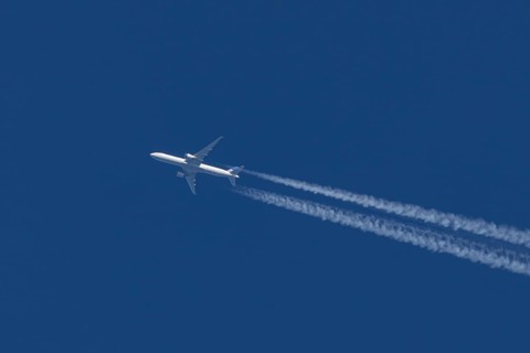 Boeing jet passenger aircraft of United airways airlines flying in a blue sky with contrails or