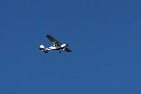 Cessna 172C Skyhawk light aircraft flying in a blue sky, England, United Kingdom