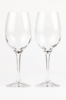 Two elegant, transparent wine glasses with long stems next to each other