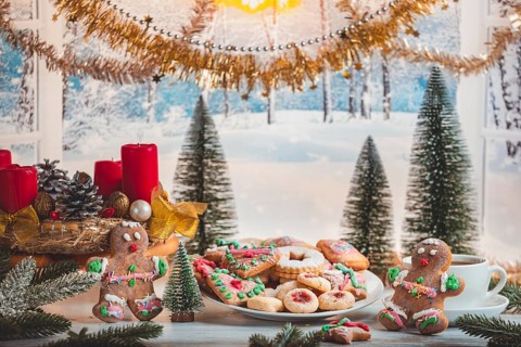 Christmas table with cookies and decorations in front of snow-white landscape