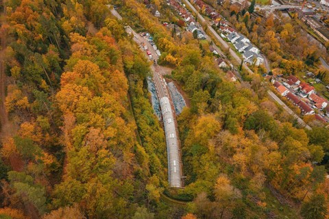 City panorama with view of a train tunnel in an autumnal forest, Hermann-Hesse-Bahn construction