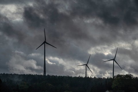 Wind turbines in pine forest during thunderstorm, Bavarian Forest, Bavaria, Germany
