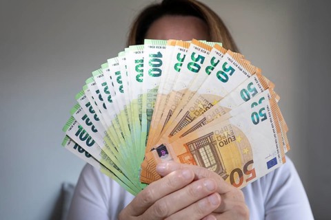 Human hand with several 50 and 100 euro banknotes