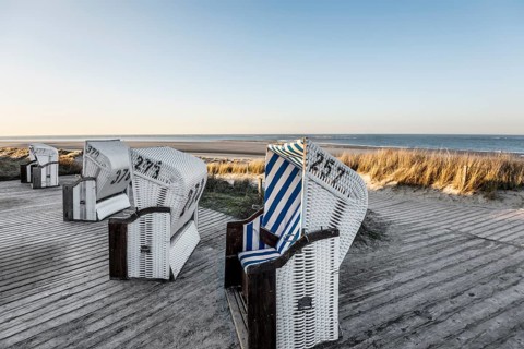 Beach chairs in the dunes and blue sky in winter, sunset, Spiekeroog, East Frisian Islands, Lower