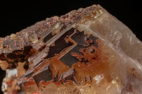 Transparent crystals sit on rocks and reveal their unique shimmer and geological structure. The