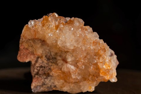 Quartz soil with sparkling crystals that are exposed on a grey surface. The lighting highlights the