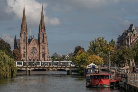 The two-towered church stands majestically on the banks of the river. Trees with golden leaves