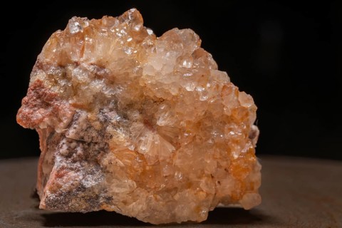 This quartz crystal with its slight orange hue shimmers in the light. Well-defined facets can be