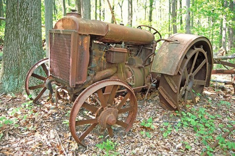 Rusted American Fordson tractor with iron tires around 1900, deposited in a wooded area, Marksboro,