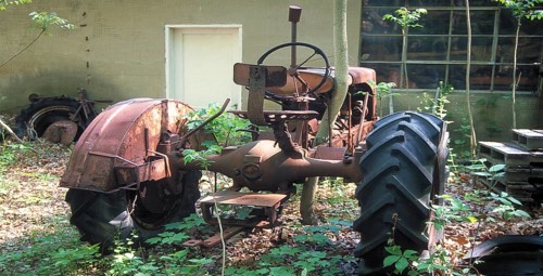 Rusted tractor at a car cemetery in a forest, Marksboro, New Jersey, USA