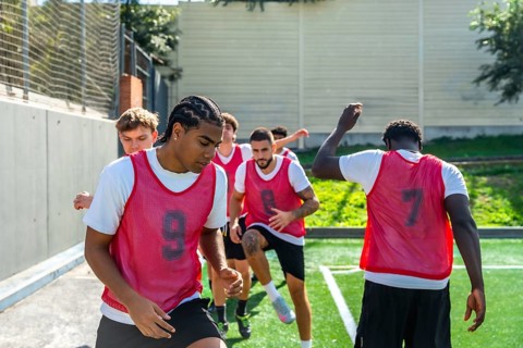 Group of diverse male soccer players engaging in intense drills and warm up exercises on an