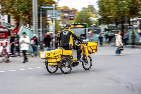 Delivery agent, Deutsche Post mailman on e-bike, Bochum, North Rhine-Westphalia, Germany