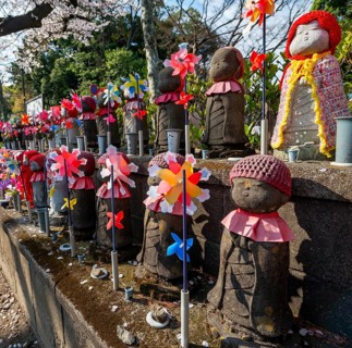 Jizo statues with red crocheted caps, guardian deities for deceased children, Unborn Children