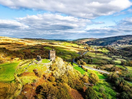 Autumn colours over Castell Dolwyddelan and Eryri Mountains from a drone, Snowdonia, Conwy County