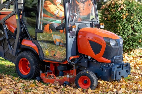 Removing leaves with a riding mower in a public park, Mutterstadt, Rheinland Pfalz