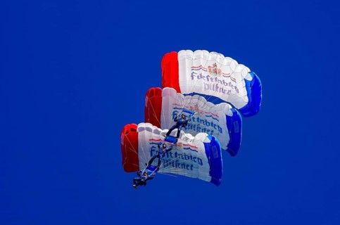 Skydivers during an aerial acrobatic performance as part of an air show at the Fliegerbergfest of