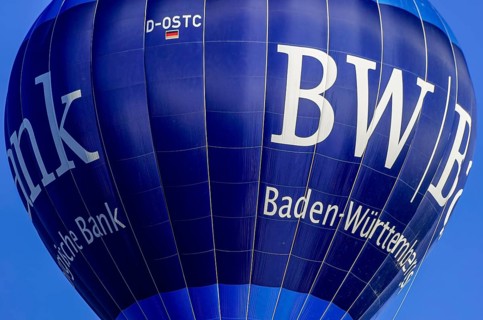 A hot air balloon, registration D-OSTC, rises into the air as part of an air show at the Rossfeld