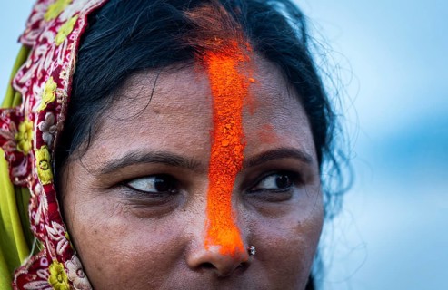 A Hindu devotee offer prayers to the Sun God on the bank of Brahmaputra river on the occasion of